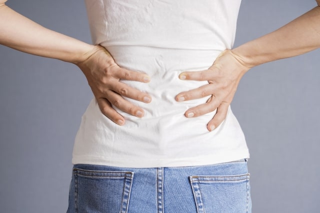 腰を抑える女性